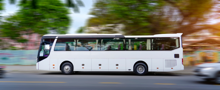 A plain charter bus driving through a city